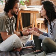 couple talking and listening on a bed