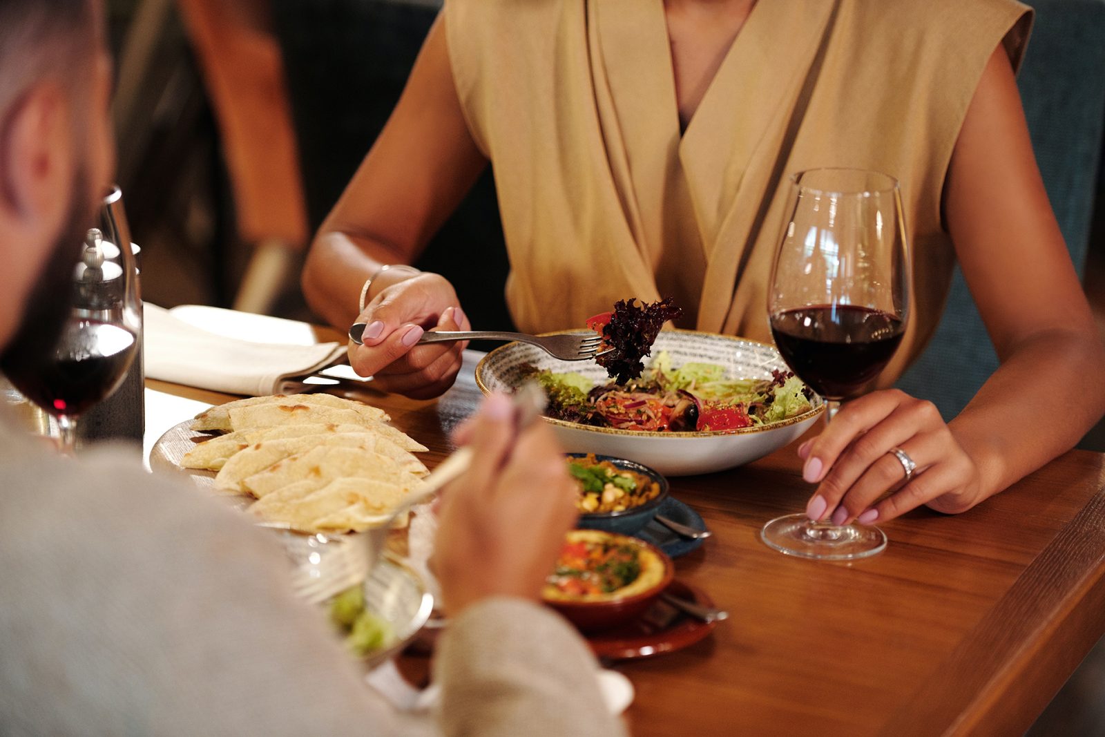 man and woman having wine over dinner