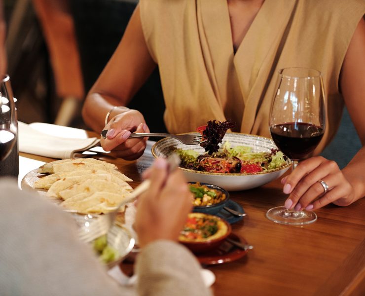 man and woman having wine over dinner