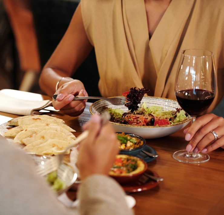man and woman having wine over dinner