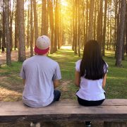 man and woman sitting on bench