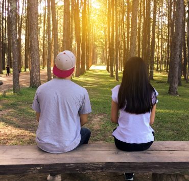 man and woman sitting on bench