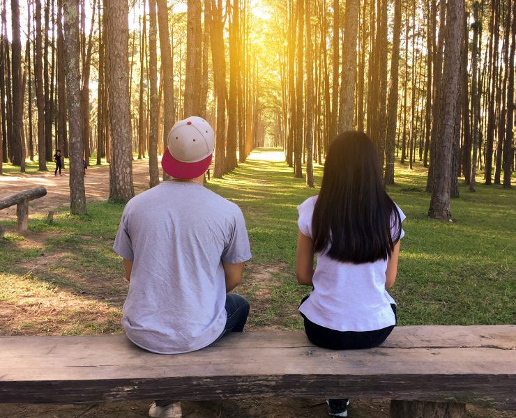 man and woman sitting on bench